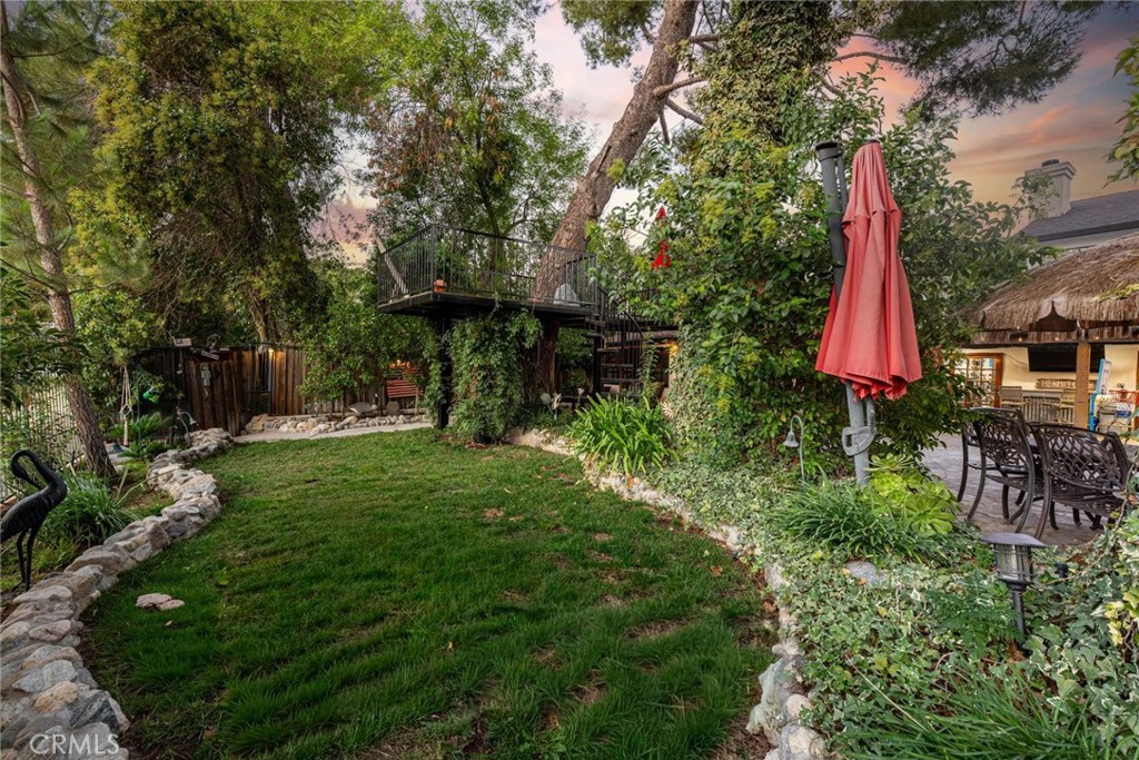 25261 Avenida Rondel Valencia, CA 91355 - Photo 47 of 68 a backyard of a house with table and chairs plants and large tree