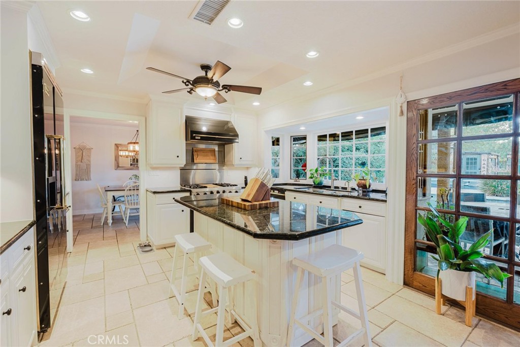 25261 Avenida Rondel Valencia, CA 91355 - Photo 9 of 68 a kitchen with stainless steel appliances granite countertop a sink a stove a dining table and chairs