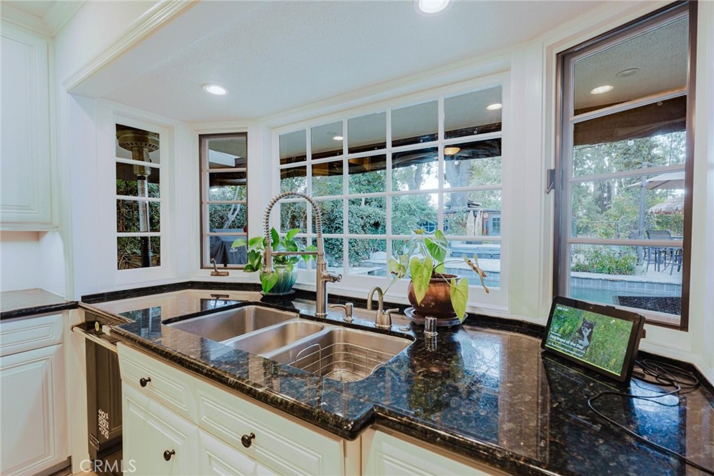 25261 Avenida Rondel Valencia, CA 91355 - Photo 10 of 68 a kitchen with granite countertop a sink and a window