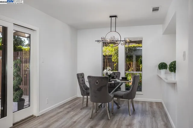 a dining room with furniture a chandelier and wooden floor