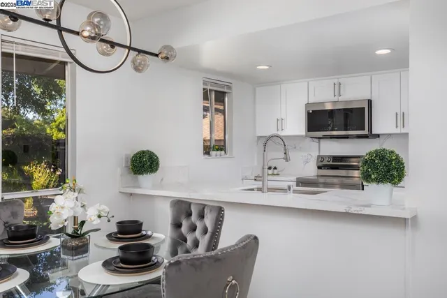 a kitchen with stainless steel appliances kitchen island granite countertop a sink a stove and a wooden floors