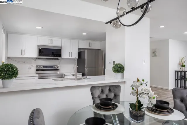 a kitchen with stainless steel appliances a microwave a stove a refrigerator and cabinets