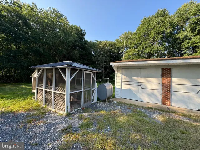 a view of a house with a yard and a large tree