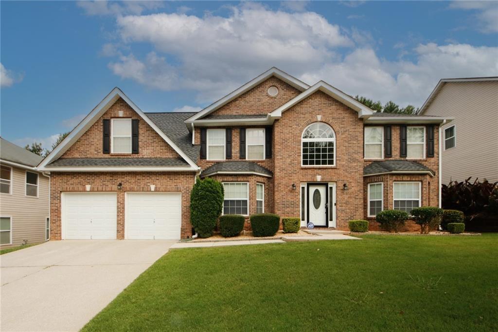 4388 Ash Tree Street Southwest Snellville, GA 30039 - Photo 1 of 1 a front view of a house with a garden and trees