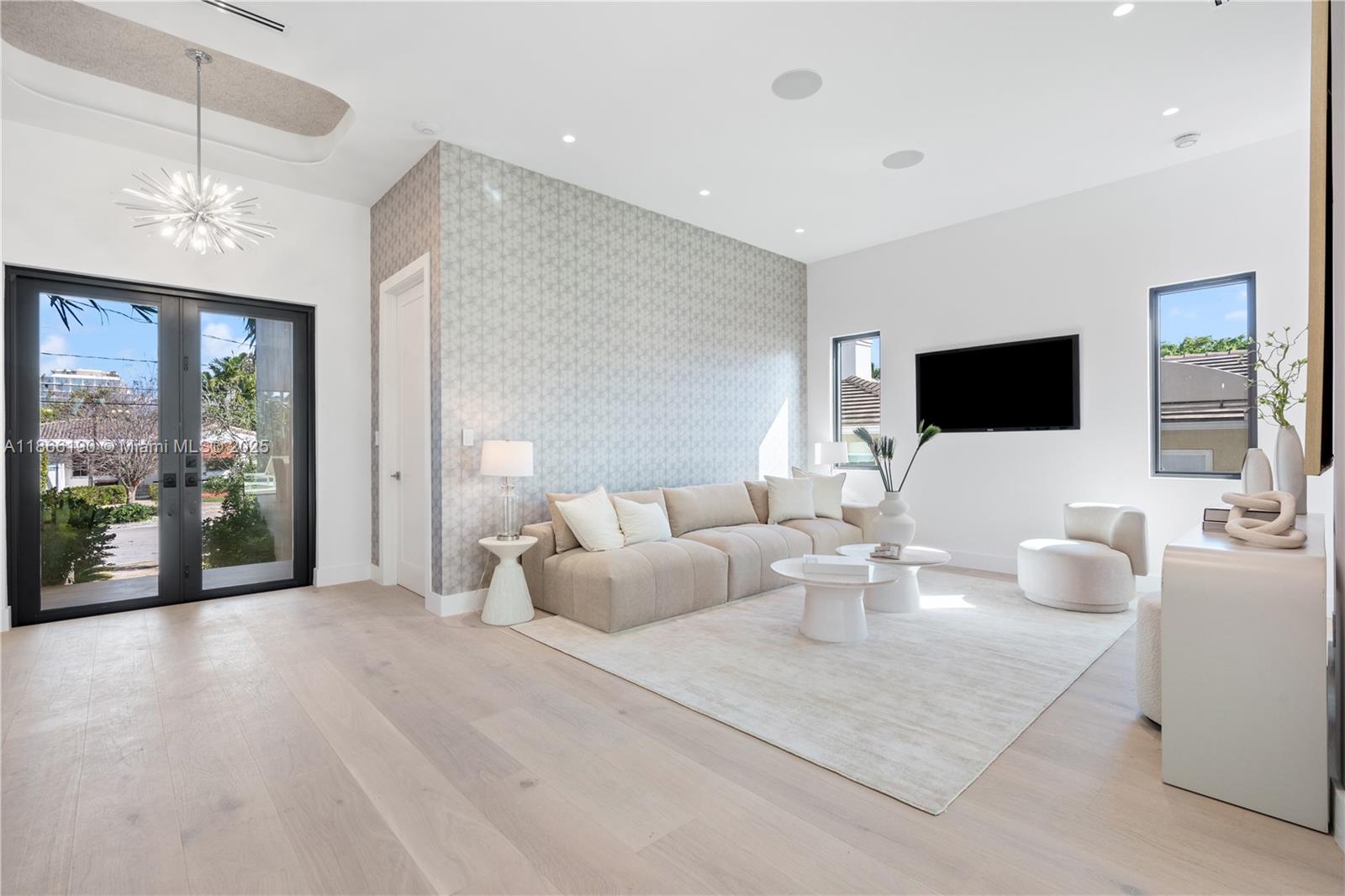 9132 Dickens Avenue Surfside, FL 33154 - Photo 4 of 37 a living room with furniture a flat screen tv and a chandelier