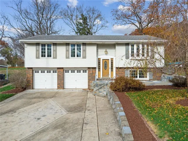 a front view of a house with a garden and plants