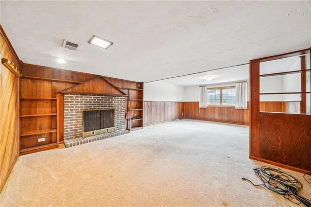 a view of an empty room with a fireplace and cabinet