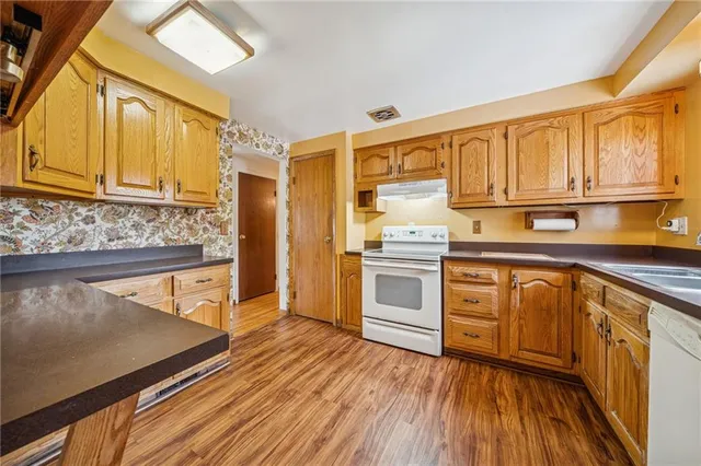 a kitchen with granite countertop wooden floors and stainless steel appliances
