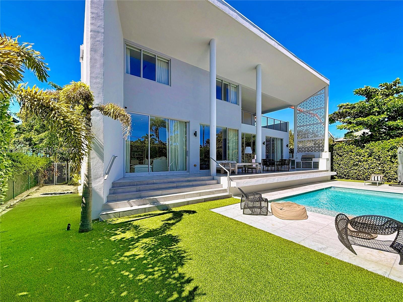 561 Warren Lane Key Biscayne, FL 33149 - Photo 18 of 30 a view of a house with swimming pool and a yard