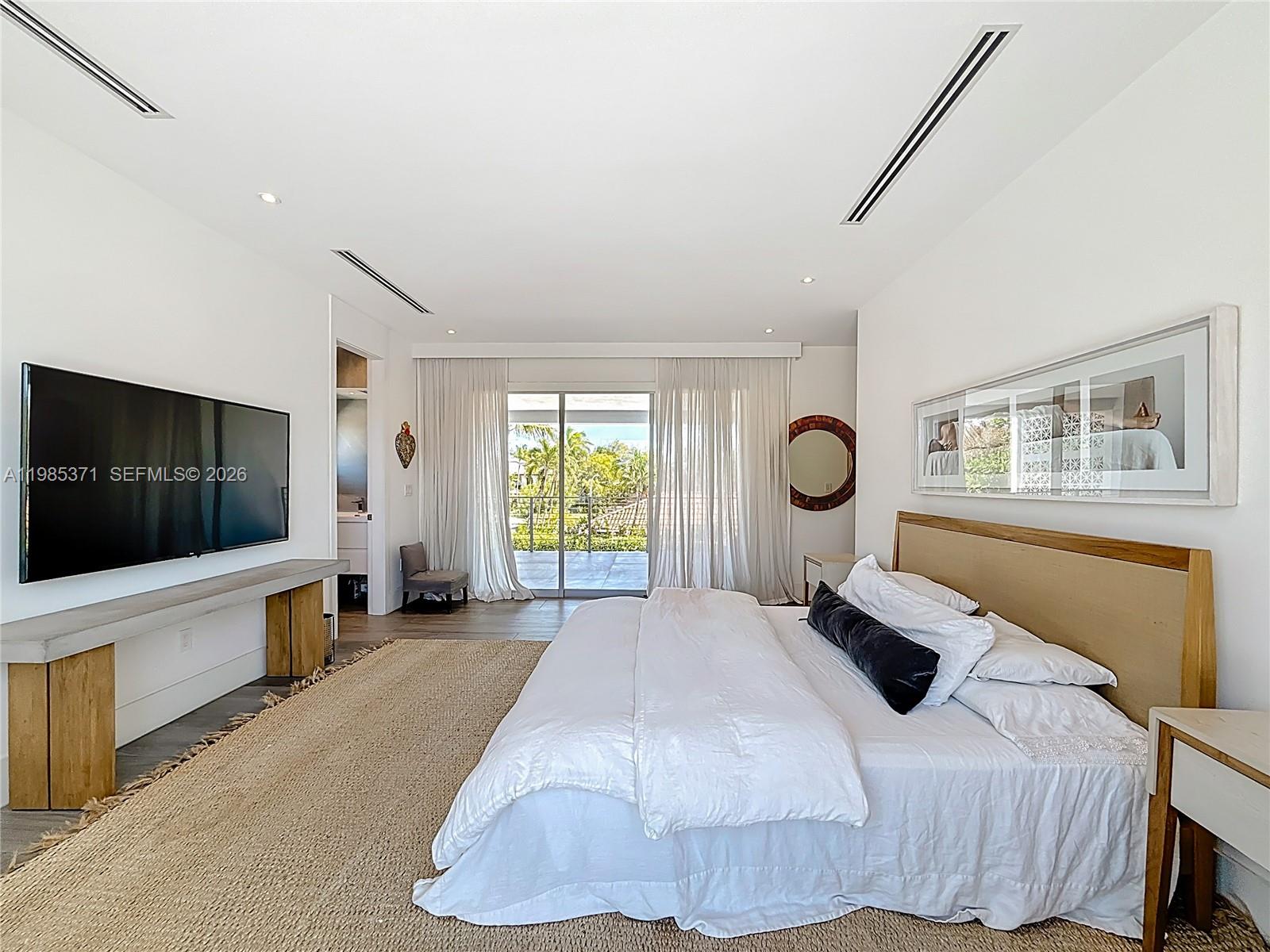 561 Warren Lane Key Biscayne, FL 33149 - Photo 22 of 30 a bedroom with a large bed and a flat screen tv