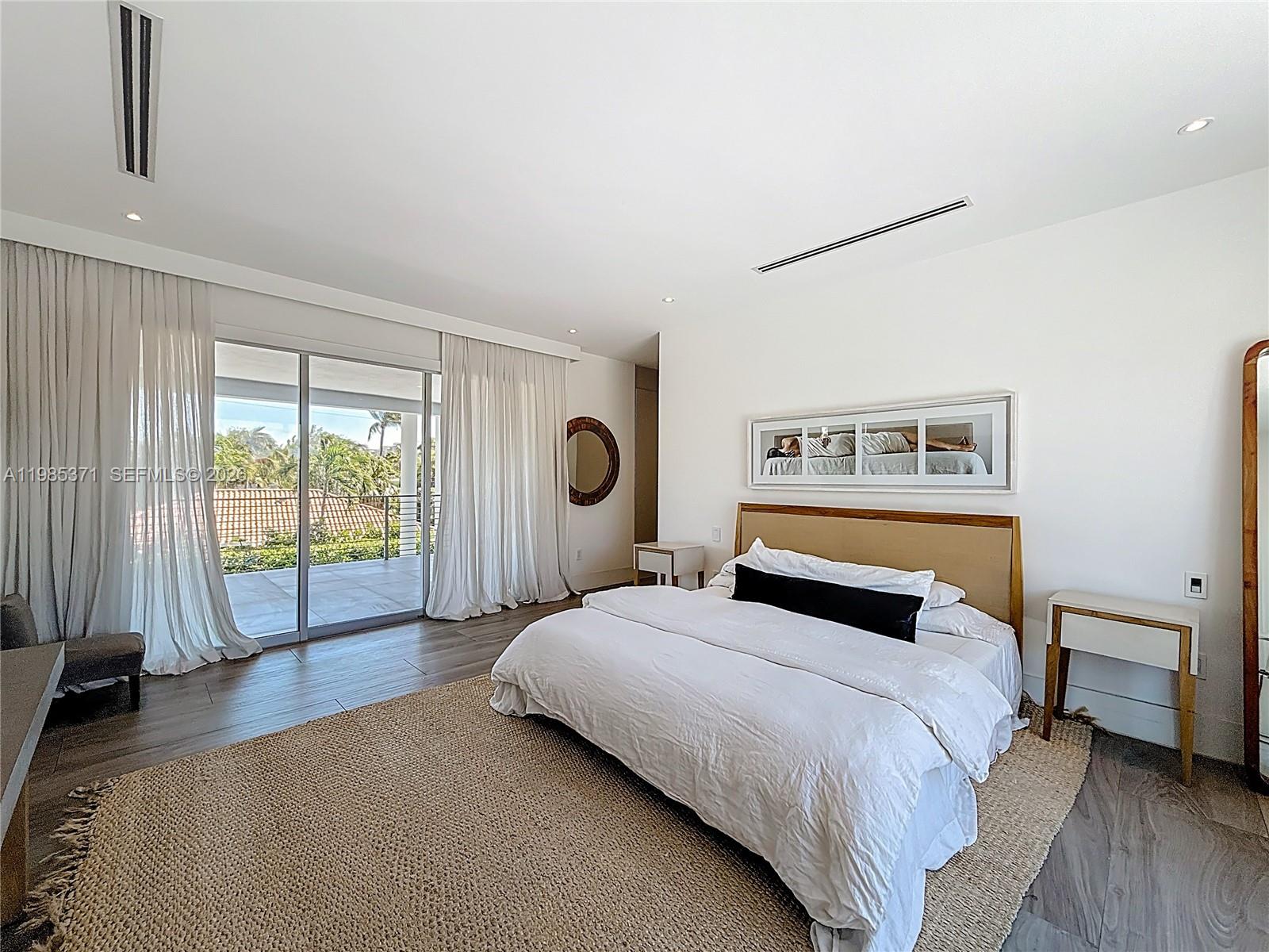 561 Warren Lane Key Biscayne, FL 33149 - Photo 23 of 30 a bedroom with a large bed and a large window