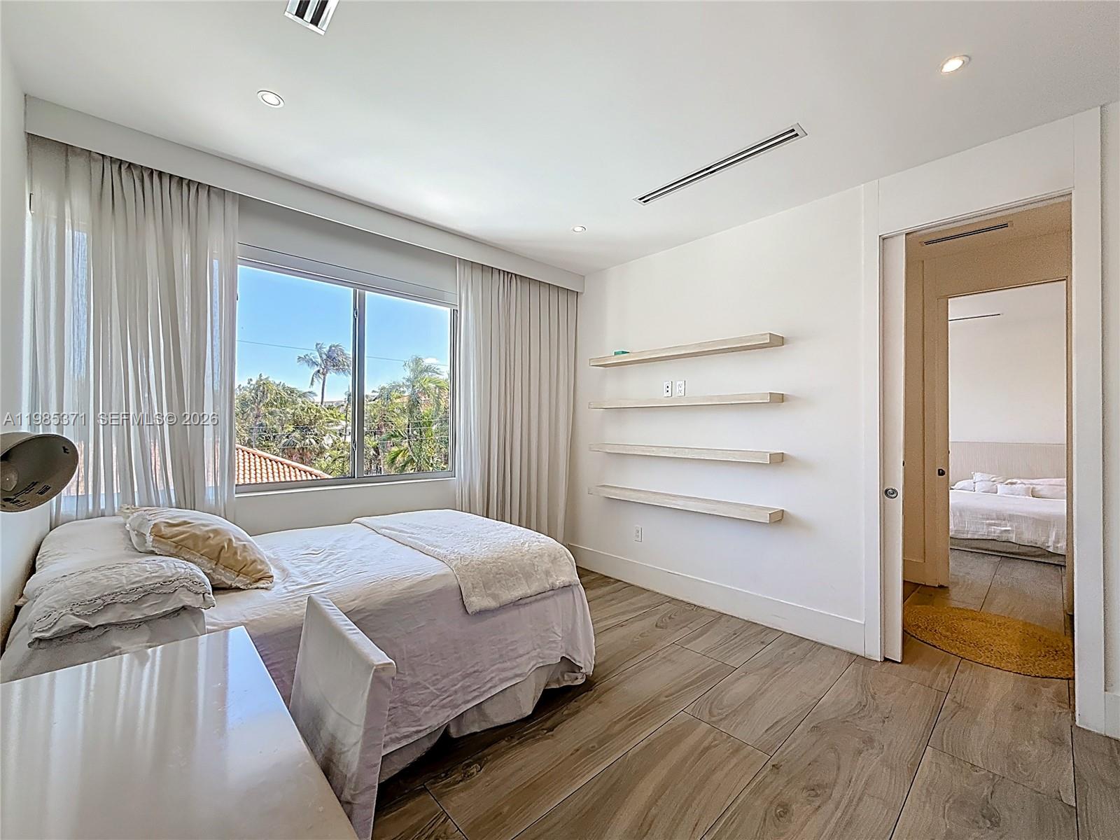 561 Warren Lane Key Biscayne, FL 33149 - Photo 24 of 30 a bedroom with a bed and a large window