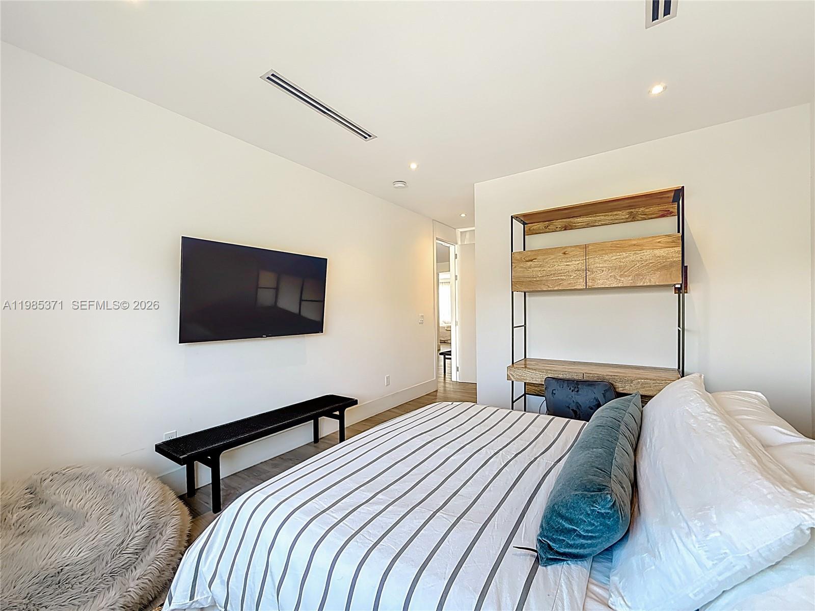 561 Warren Lane Key Biscayne, FL 33149 - Photo 28 of 30 a bedroom with a bed and a flat screen tv