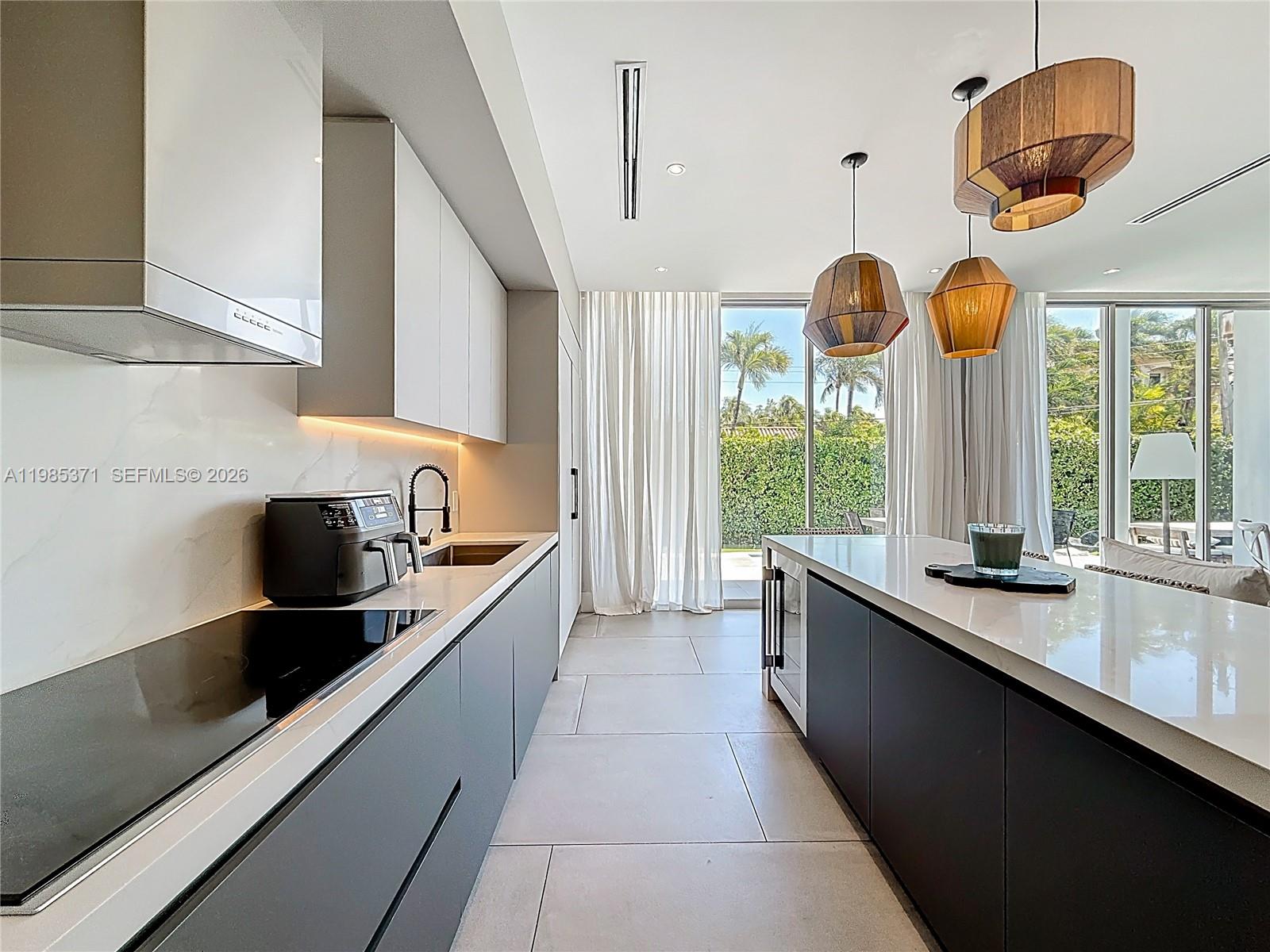 561 Warren Lane Key Biscayne, FL 33149 - Photo 7 of 30 a kitchen with stainless steel appliances granite countertop a sink and a large window