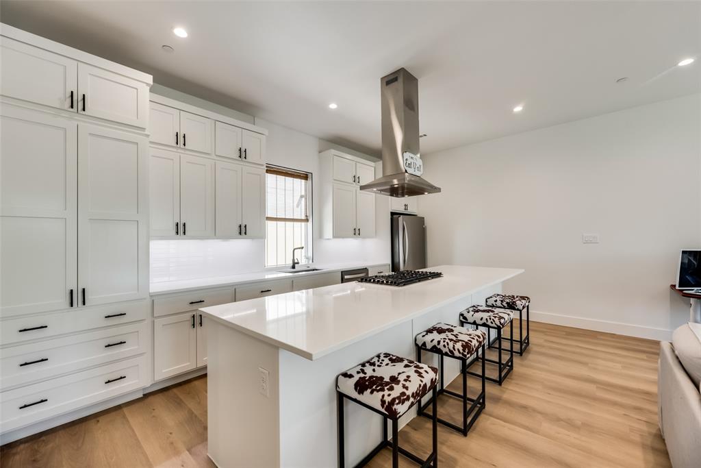 a kitchen with a sink a stove and chairs