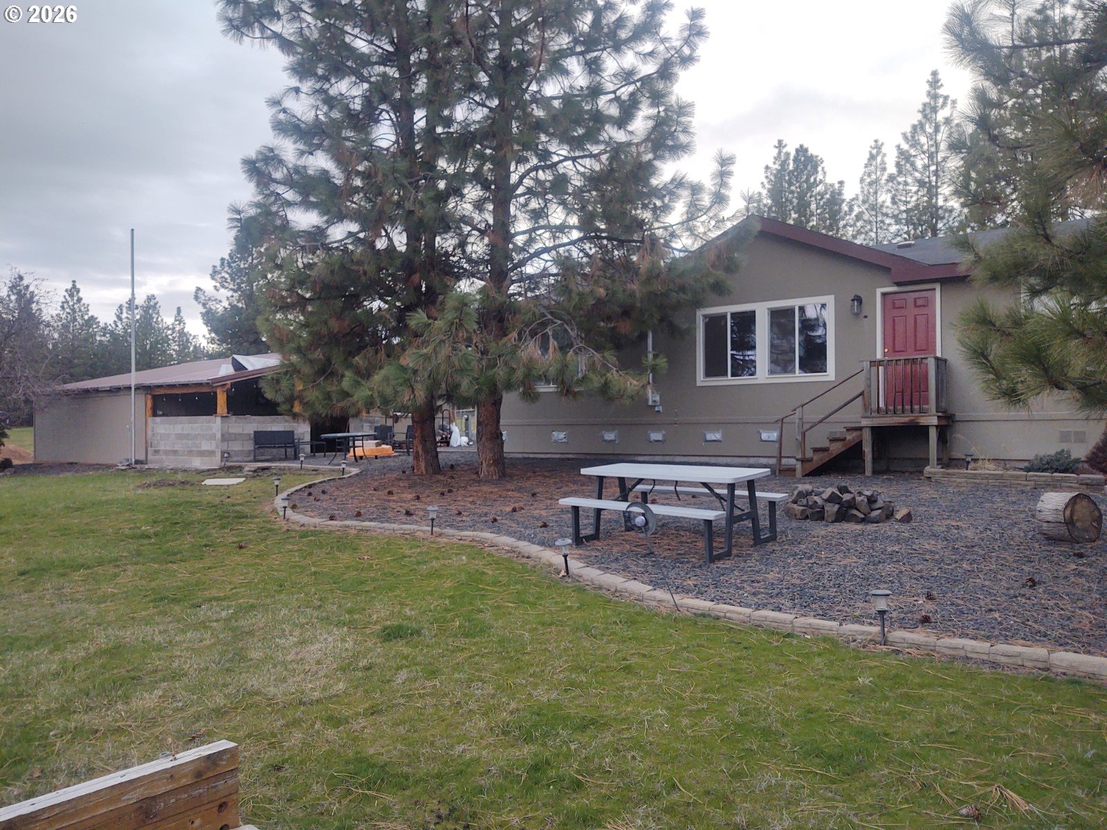 a view of a house with a yard and a bench