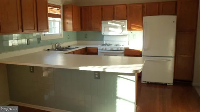 a kitchen with stainless steel appliances a refrigerator a sink a stove a microwave a sink and cabinets