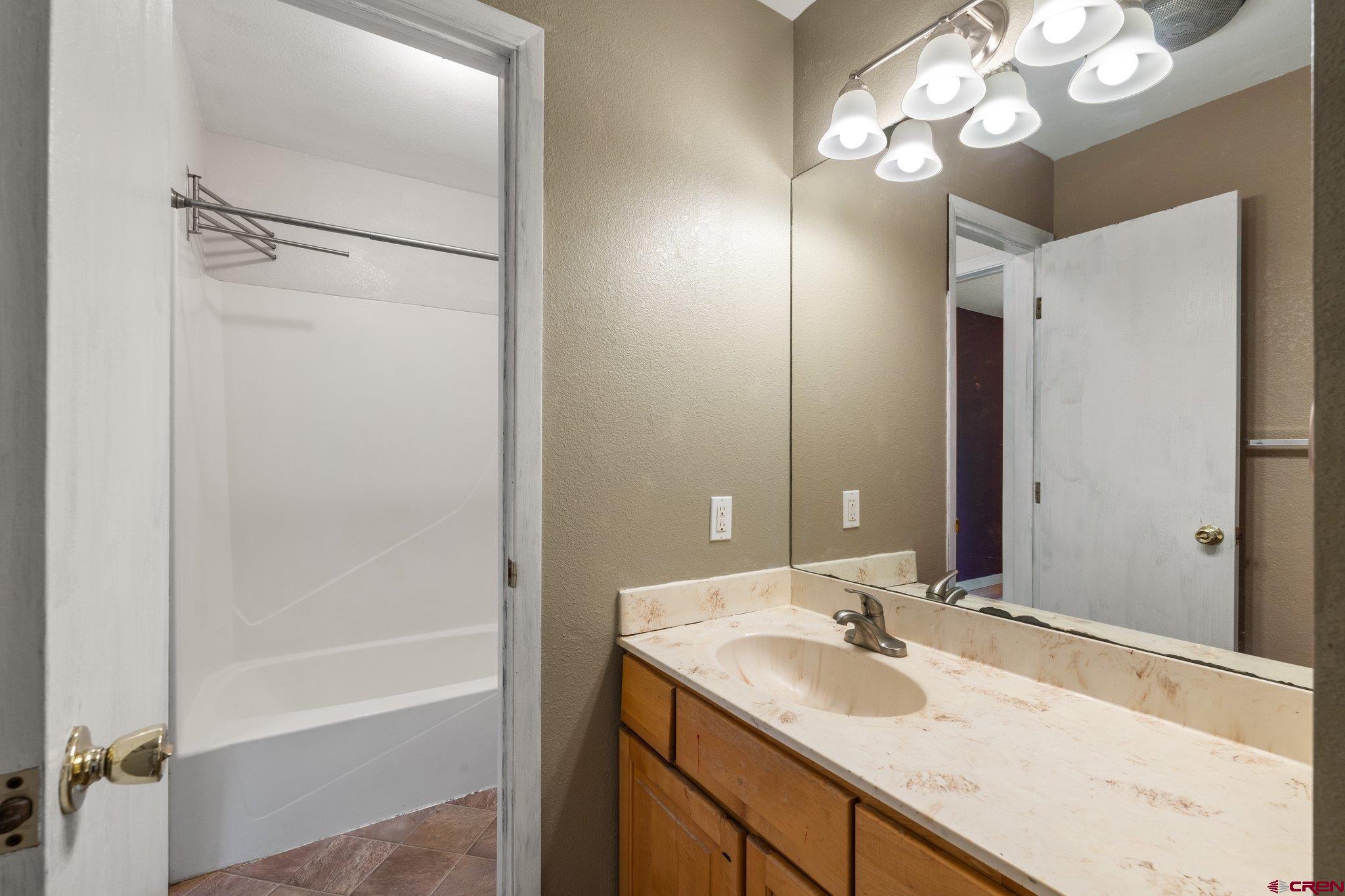 386 Needham Circle Durango, CO 81301 - Photo 20 of 32 a bathroom with a sink a mirror and a shower