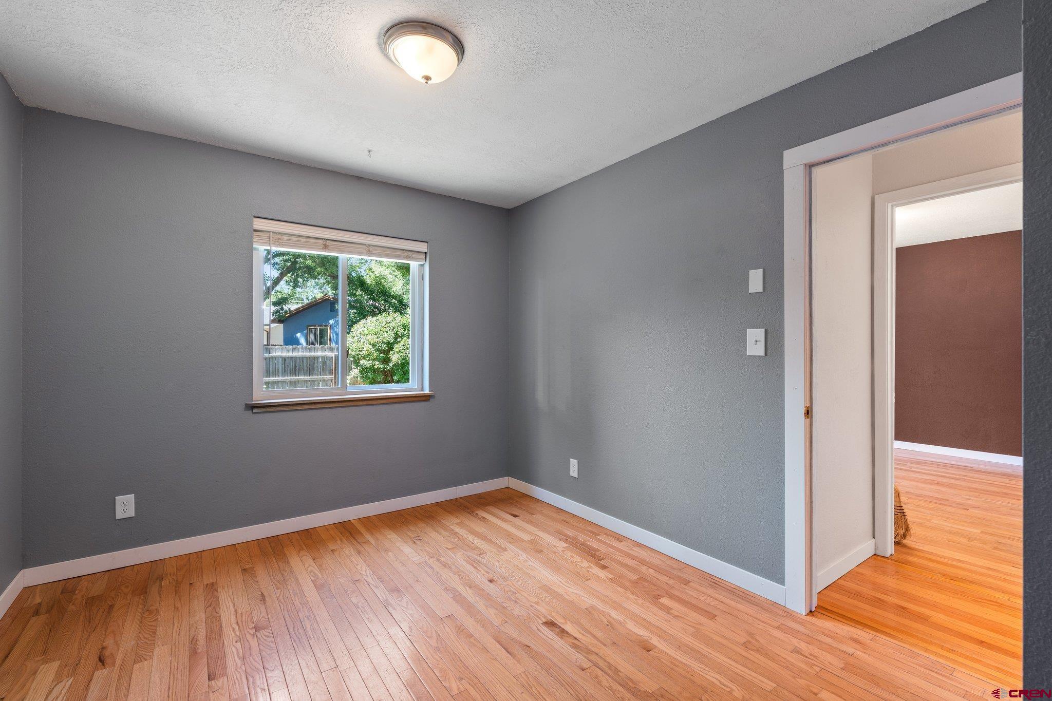386 Needham Circle Durango, CO 81301 - Photo 21 of 32 an empty room with wooden floor and windows