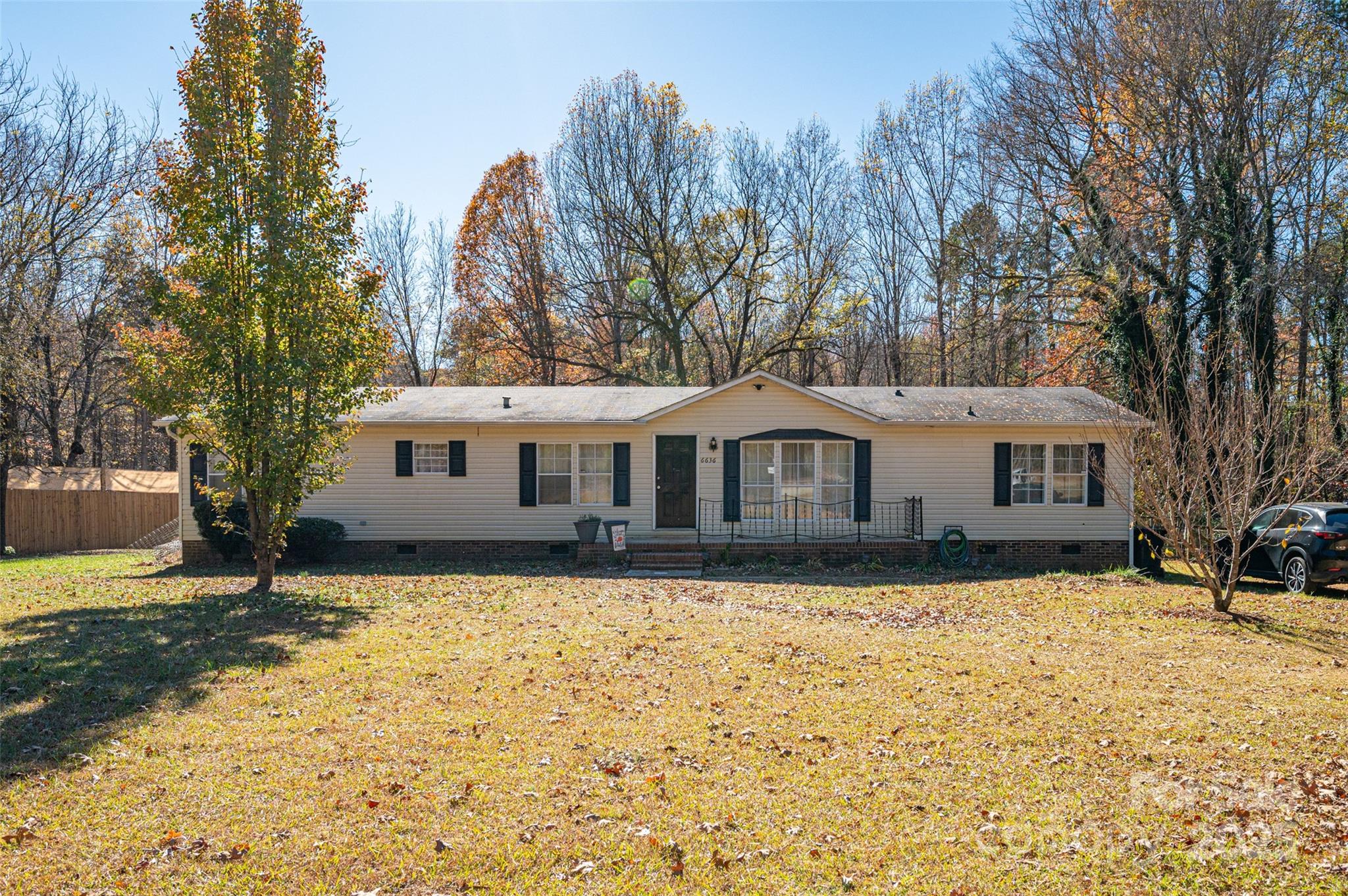 a front view of a house with a yard and trees