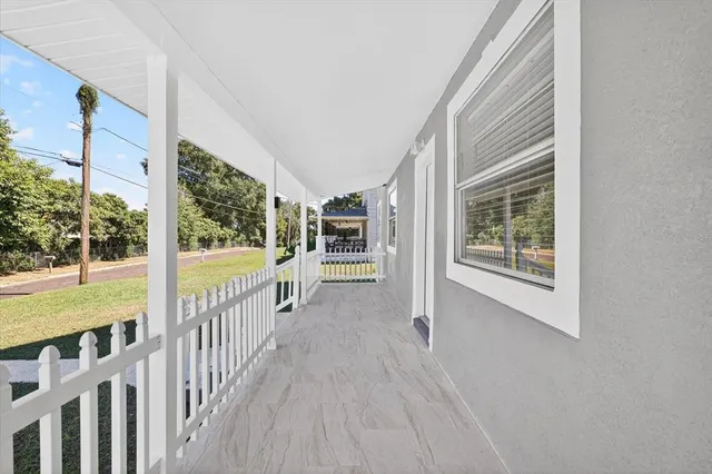 a view of a two room with wooden floor and windows