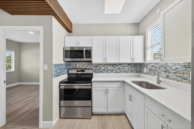 a kitchen with sink a microwave and cabinets