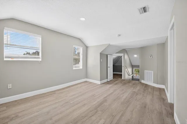 a view of empty room with wooden floor and fireplace