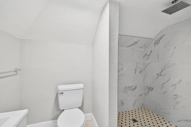 a white toilet sitting next to a shower