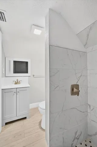 a bathroom with a toilet a sink and mirror