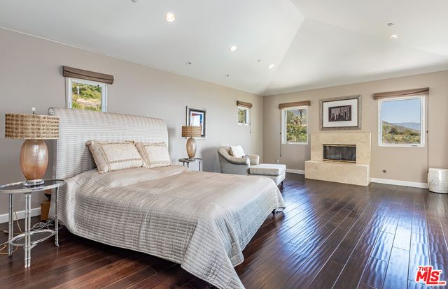 a spacious bedroom with a bed and wooden floor