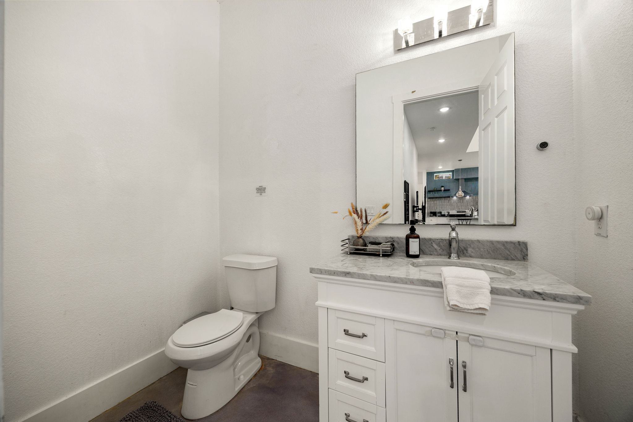 12808 Hughes Street Austin, TX 78732 - Photo 18 of 40 a bathroom with a granite countertop toilet sink and mirror