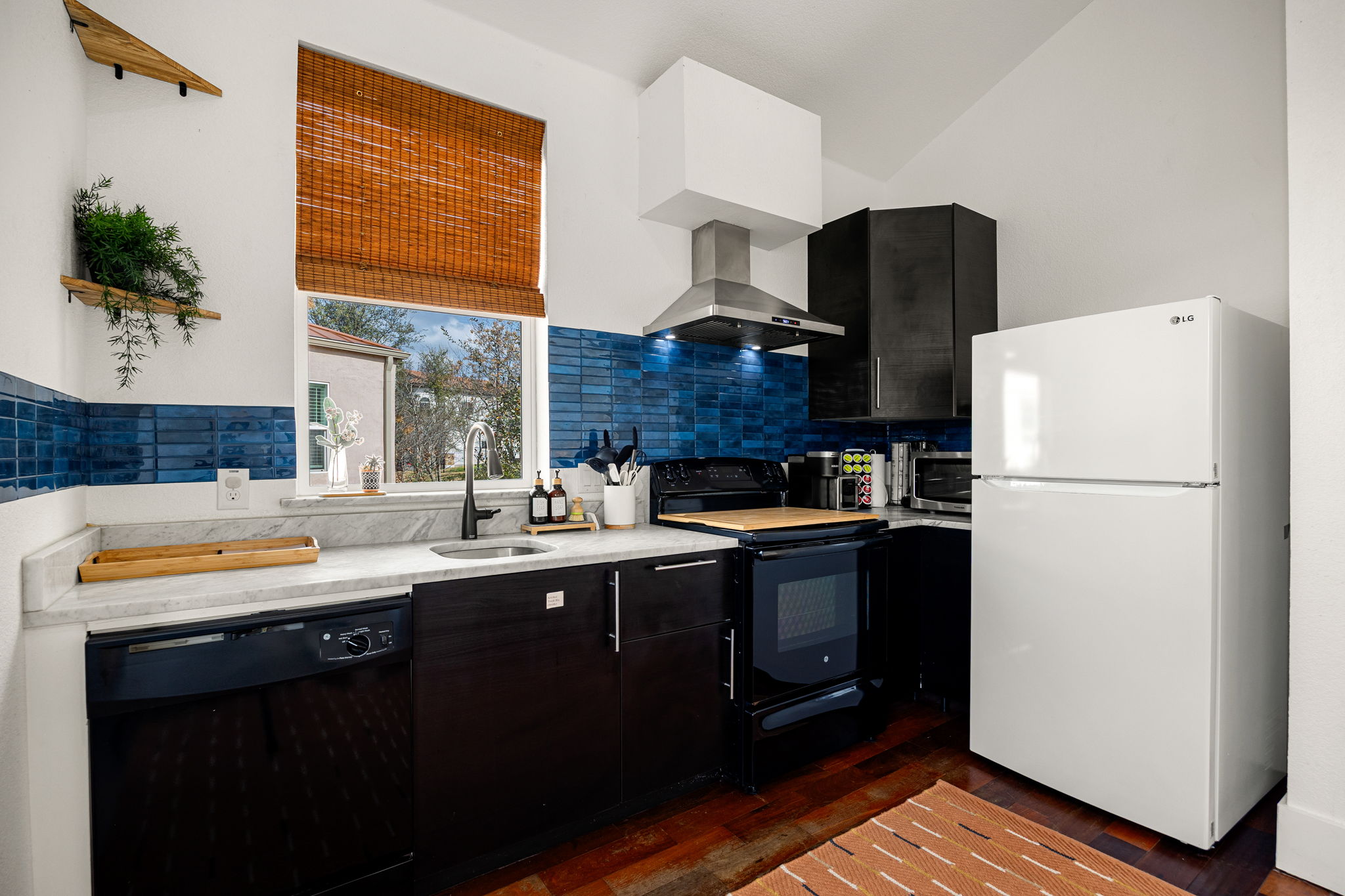 12808 Hughes Street Austin, TX 78732 - Photo 32 of 40 a kitchen with stainless steel appliances a sink cabinets and a refrigerator