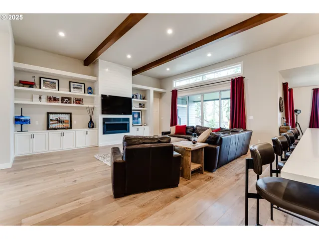 a living room with furniture flat screen tv and wooden floor