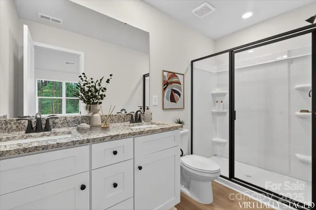 a bathroom with a granite countertop sink toilet and shower