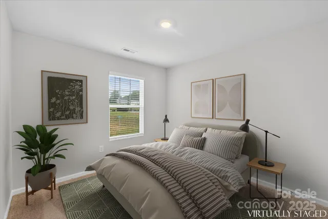 a bedroom with a bed and a potted plant