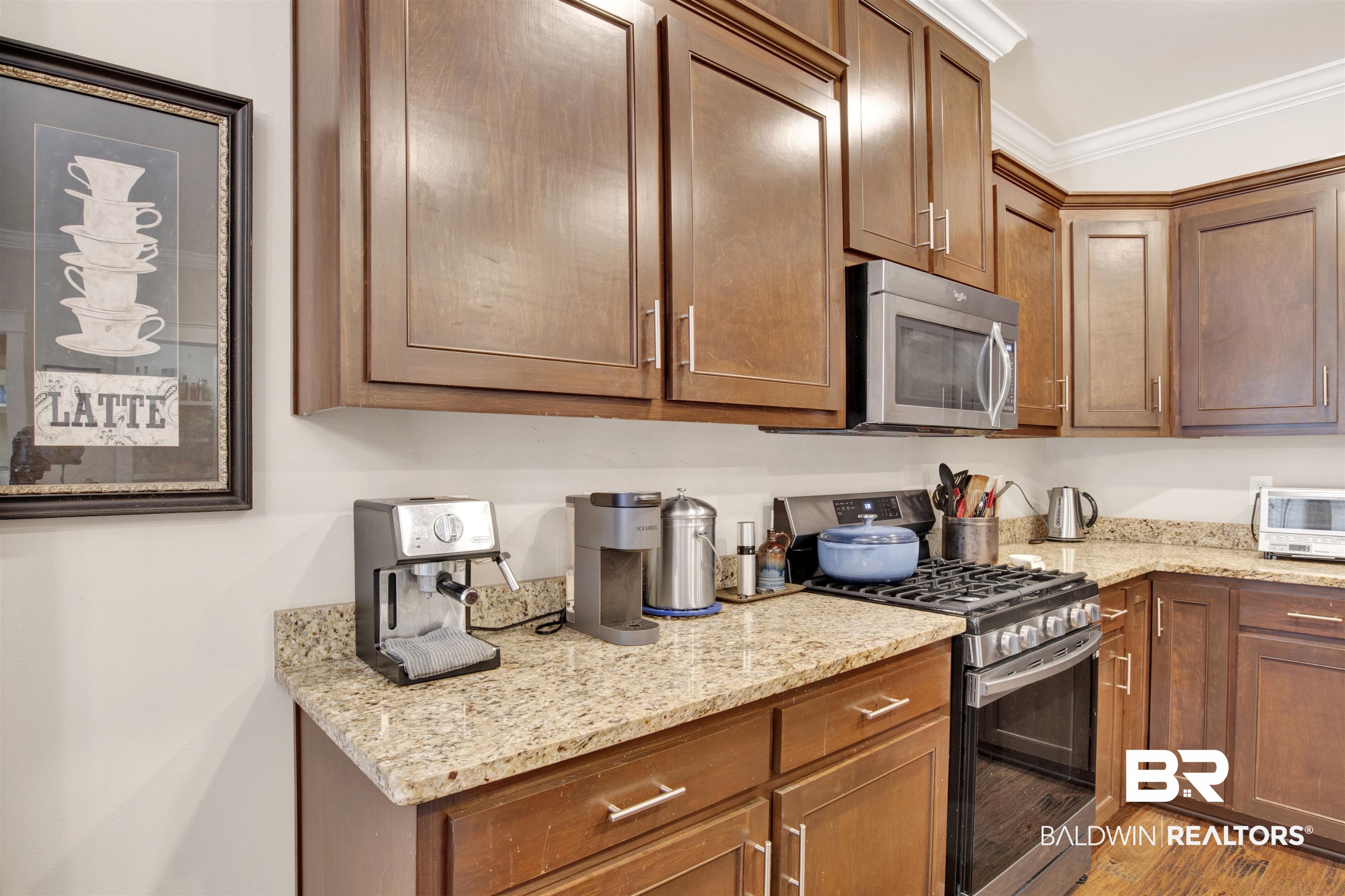 360 Scarlett Avenue Fairhope, AL 36532 - Photo 14 of 34 Kitchen with appliances with stainless steel finishes, light wood-type flooring, ornamental molding, and light stone countertops