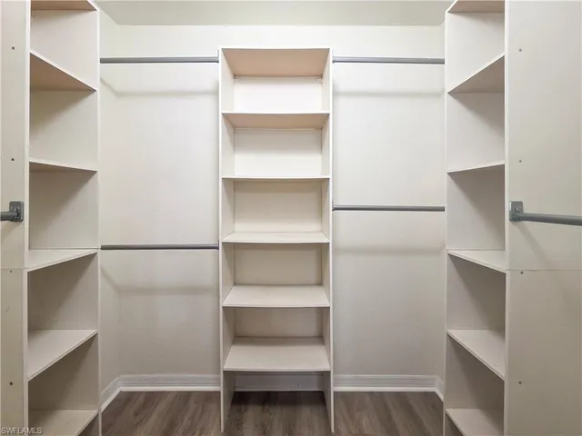 a view of walk in closet with empty racks