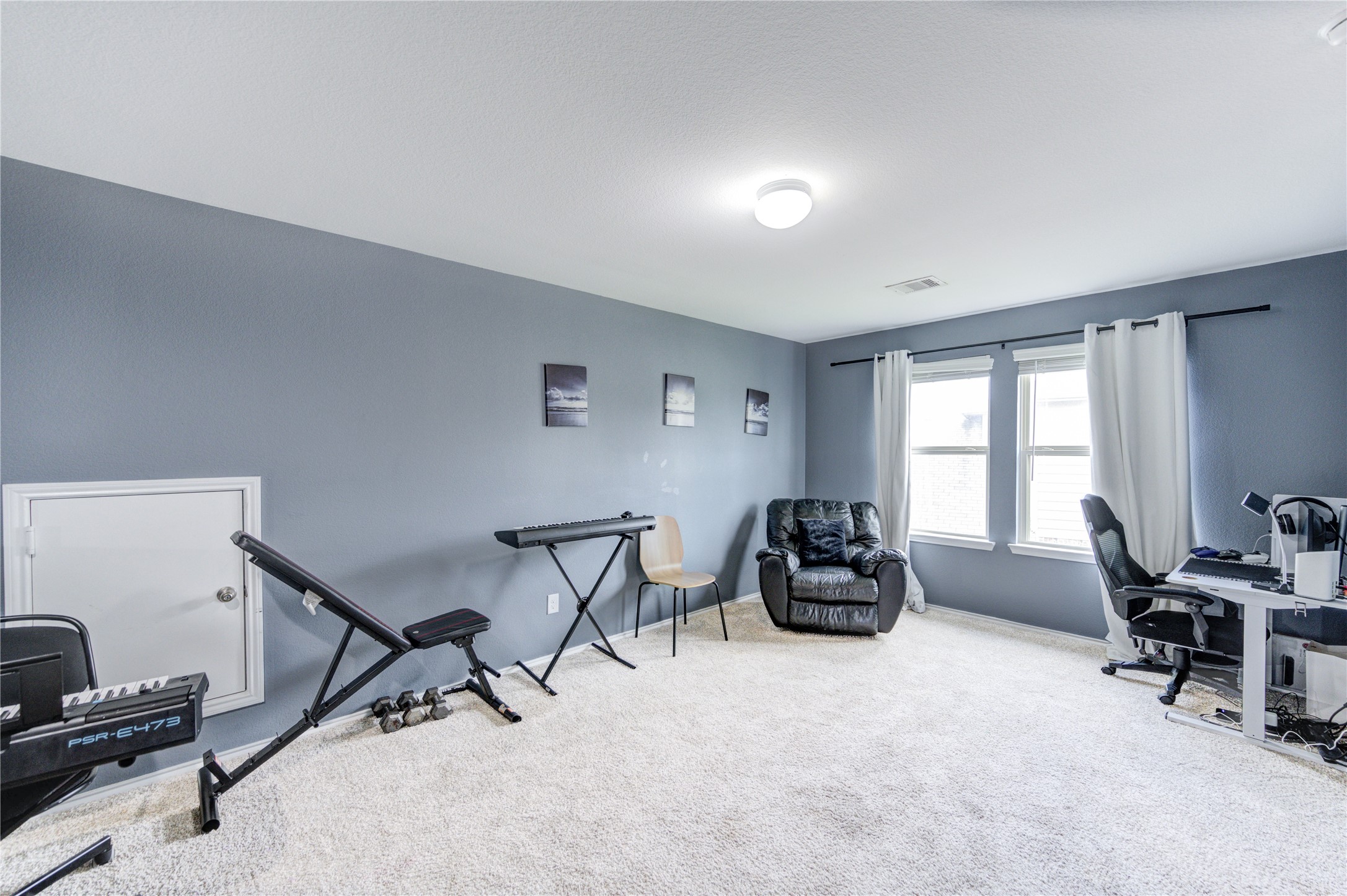 2306 Rainier Mist Road Spring, TX 77373 - Photo 9 of 28 Game room - Bright and spacious with soft carpeting, perfect for a home office or music studio. Features include large windows for natural light, a neutral color palette, and ample space for various setups.