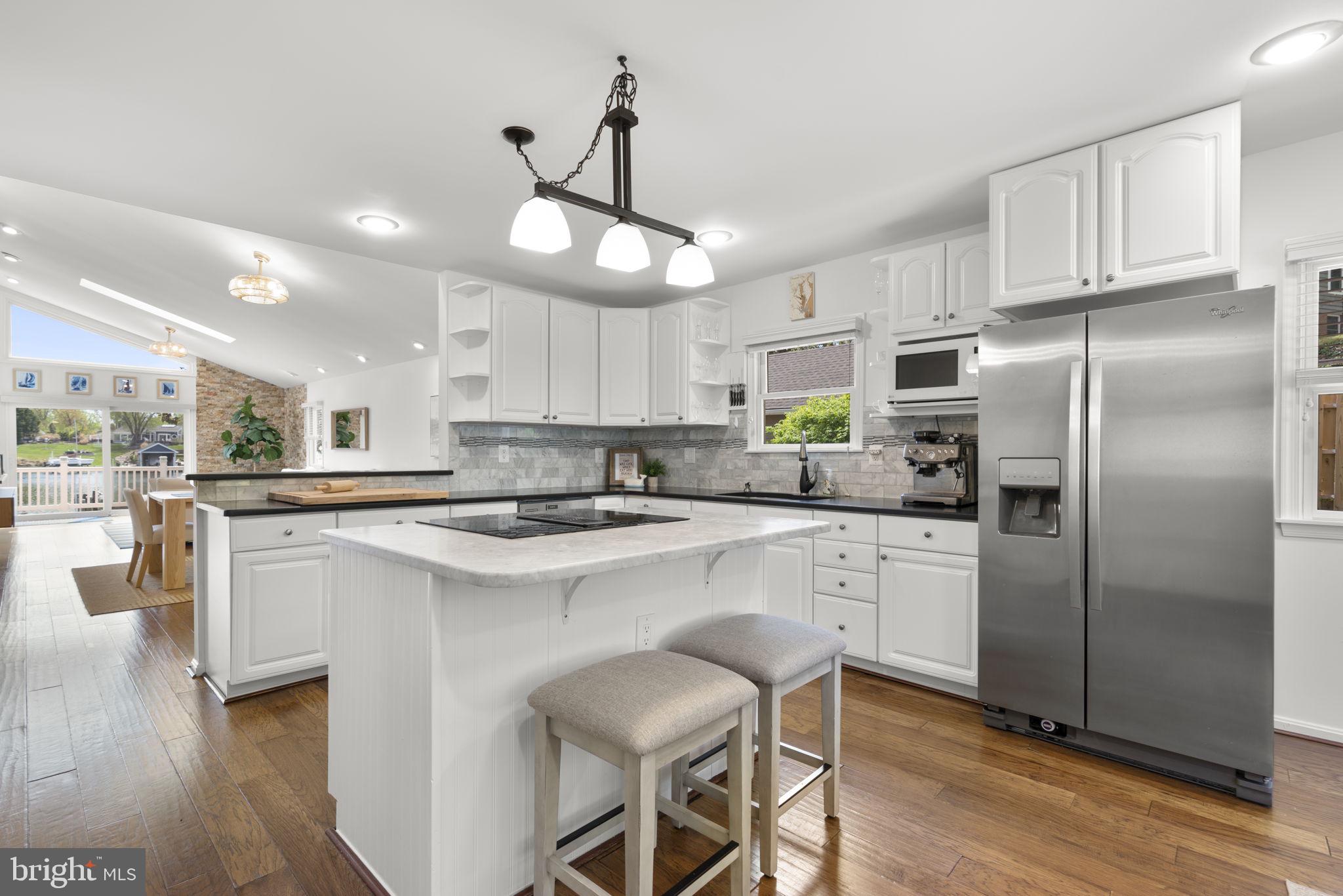 25 Leeland Road Edgewater, MD 21037 - Photo 8 of 48 a kitchen with stainless steel appliances granite countertop a stove a refrigerator a oven a sink a island with a dining table and chairs