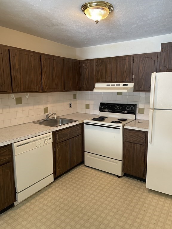 388 Great Road, Unit A11 Acton, MA 01720 - Photo 2 of 11 a kitchen with a stove a sink and a refrigerator