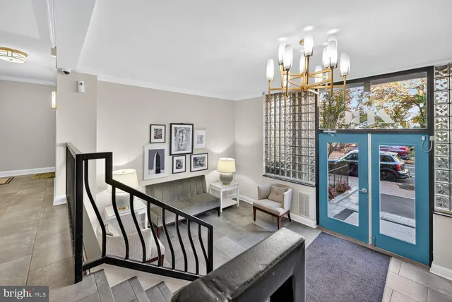 a living room with furniture a chandelier and a large window