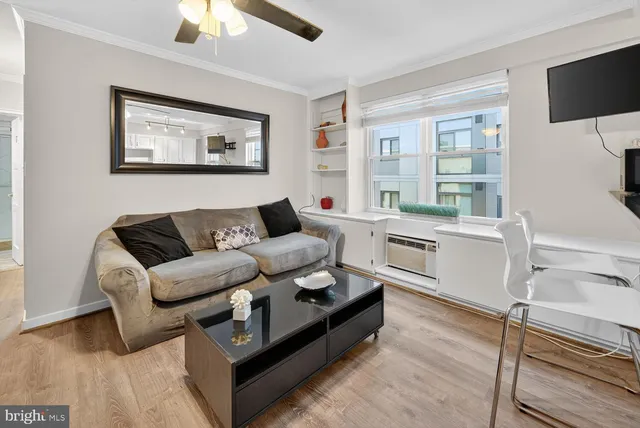 a living room with furniture a flat screen tv and a table