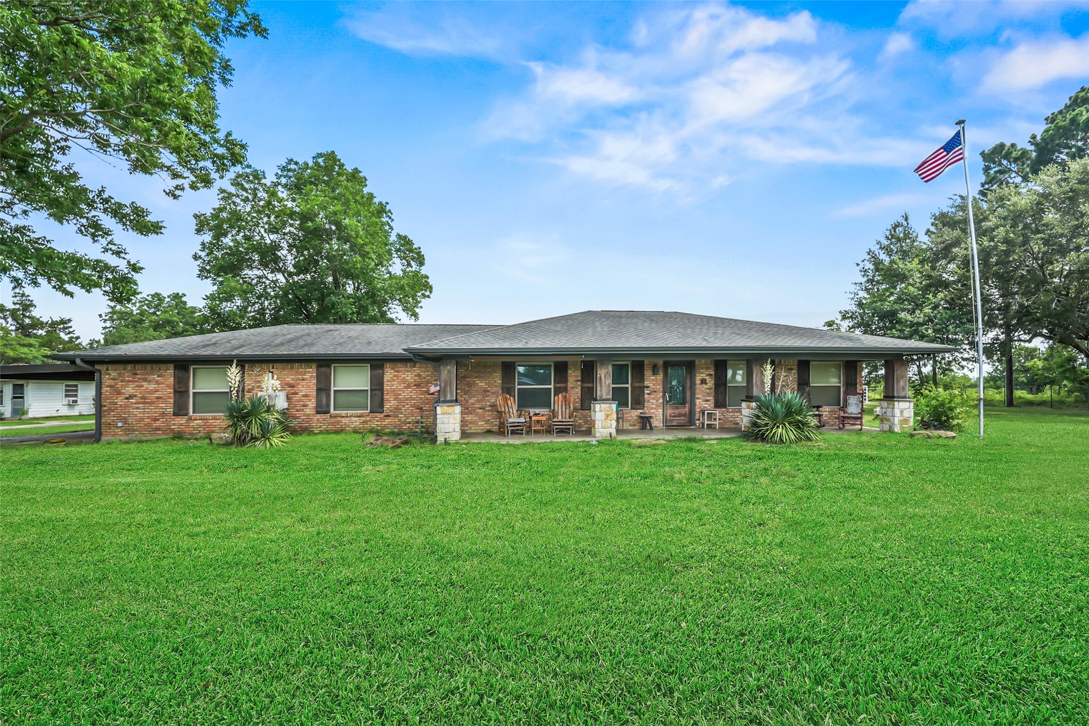 34366 Owens Road Hempstead, TX 77445 - Photo 2 of 46 Charming single-story brick home with a spacious front yard, mature shade trees, and a welcoming covered front porch offering plenty of curb appeal and outdoor space.