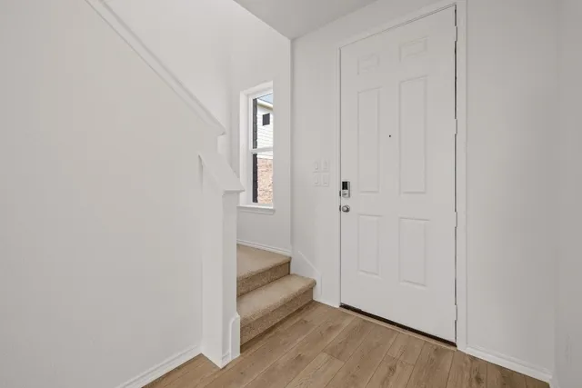 a view of a hallway with wooden floor and closet