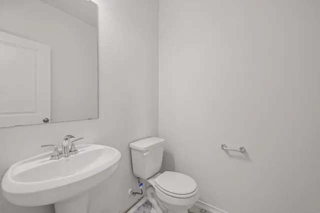a bathroom with a sink a toilet and mirror
