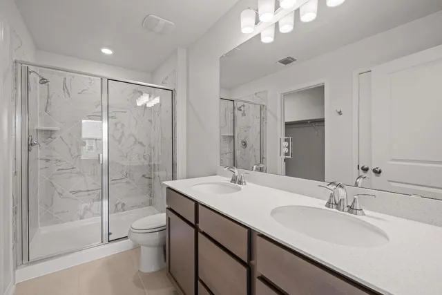 a bathroom with a double vanity sink mirror and toilet
