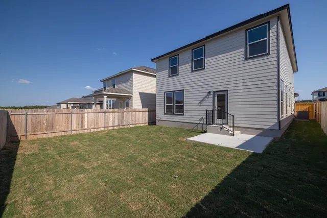 a view of a house with backyard and sitting area