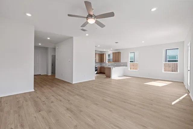 an empty room with wooden floor and windows