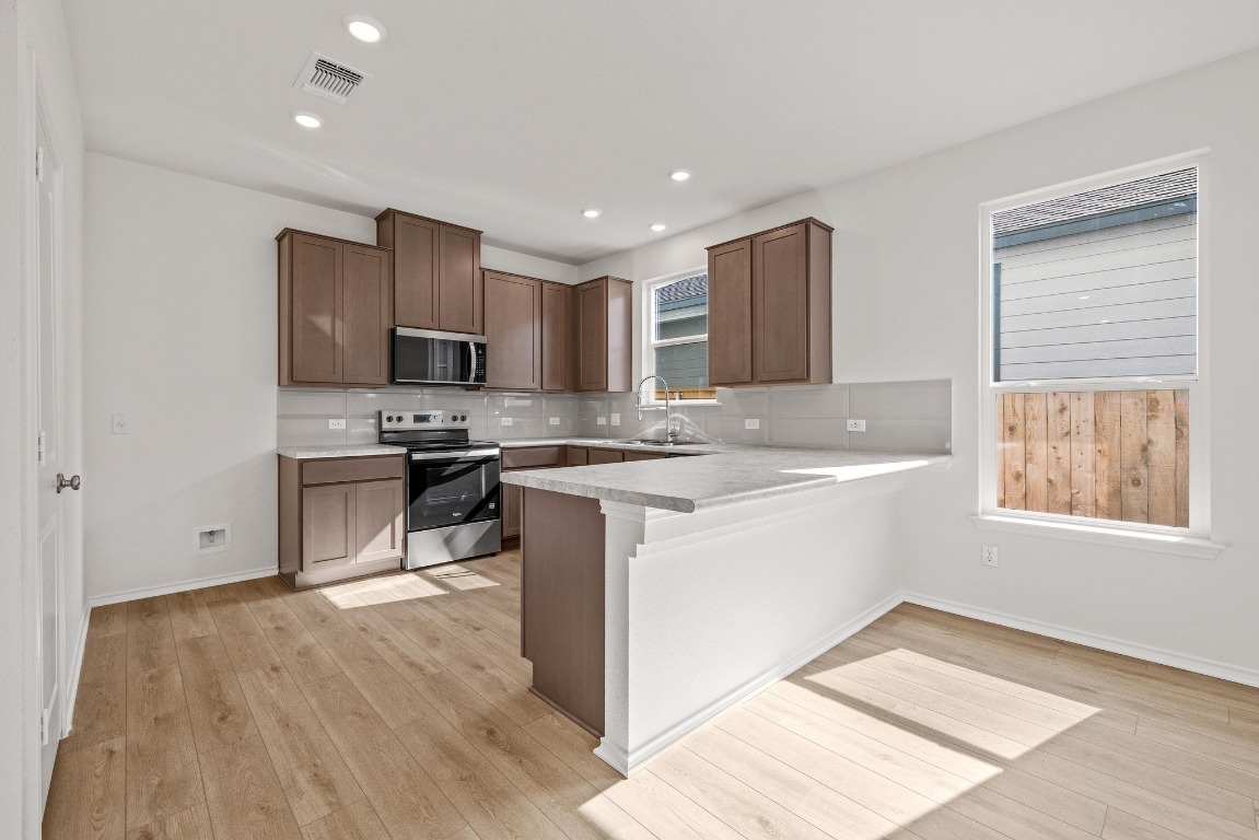 161 Lucky Texan Road Jarrell, TX 76537 - Photo 9 of 32 a kitchen with stainless steel appliances granite countertop a stove a sink and a refrigerator