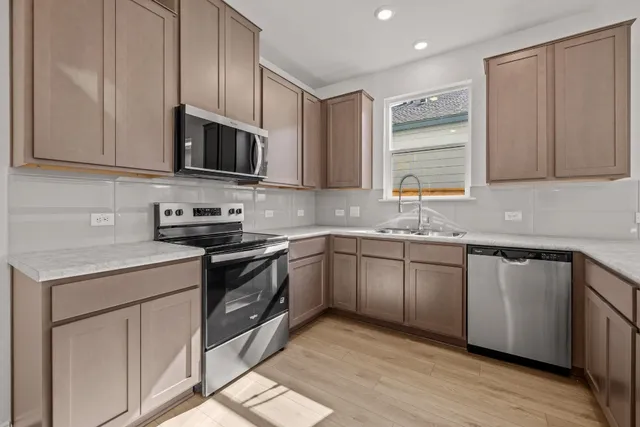 a kitchen with stainless steel appliances granite countertop a sink a stove a microwave and cabinets